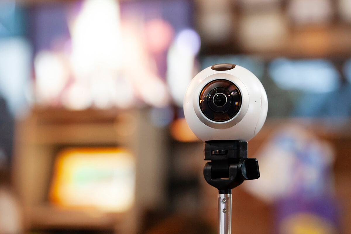 360-Grad-Kamera auf Stativ vor buntem Hintergrund