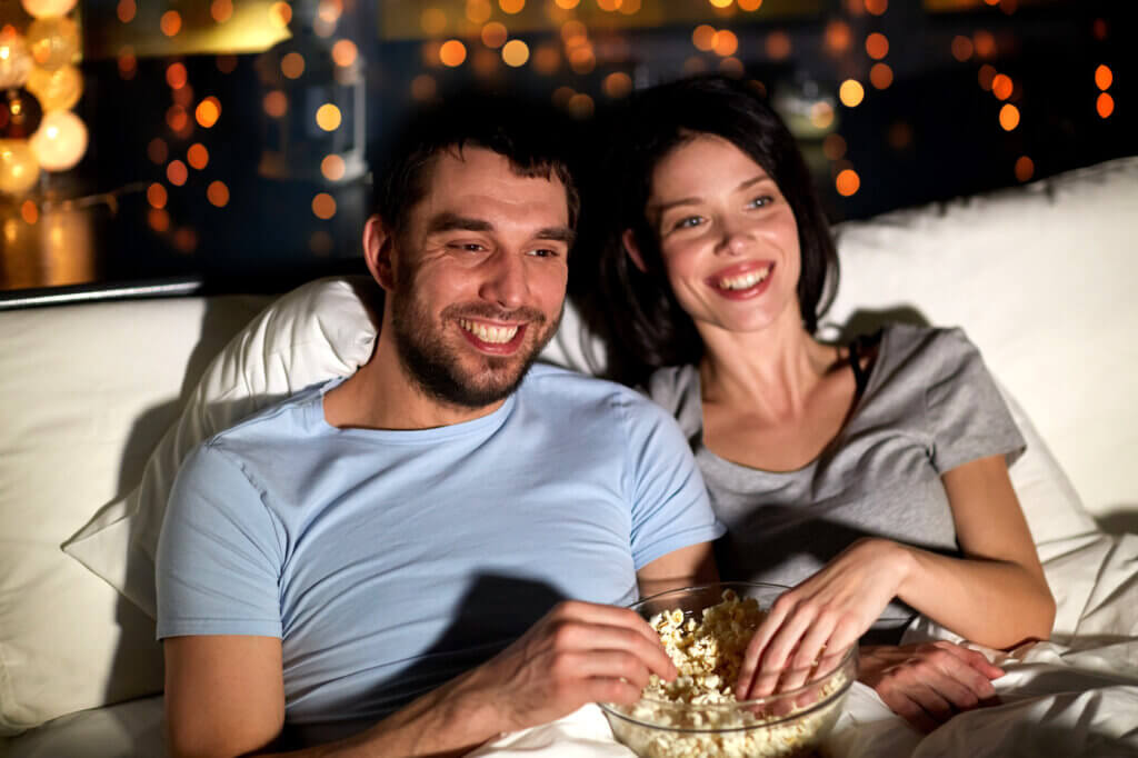 paerchen sitzt auf dem sofa. gucken film und essen popcorn