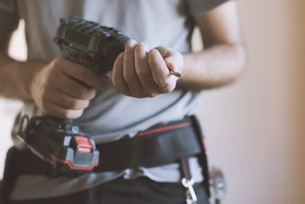 Handwerker befestigt Bit in Bohrmaschine 