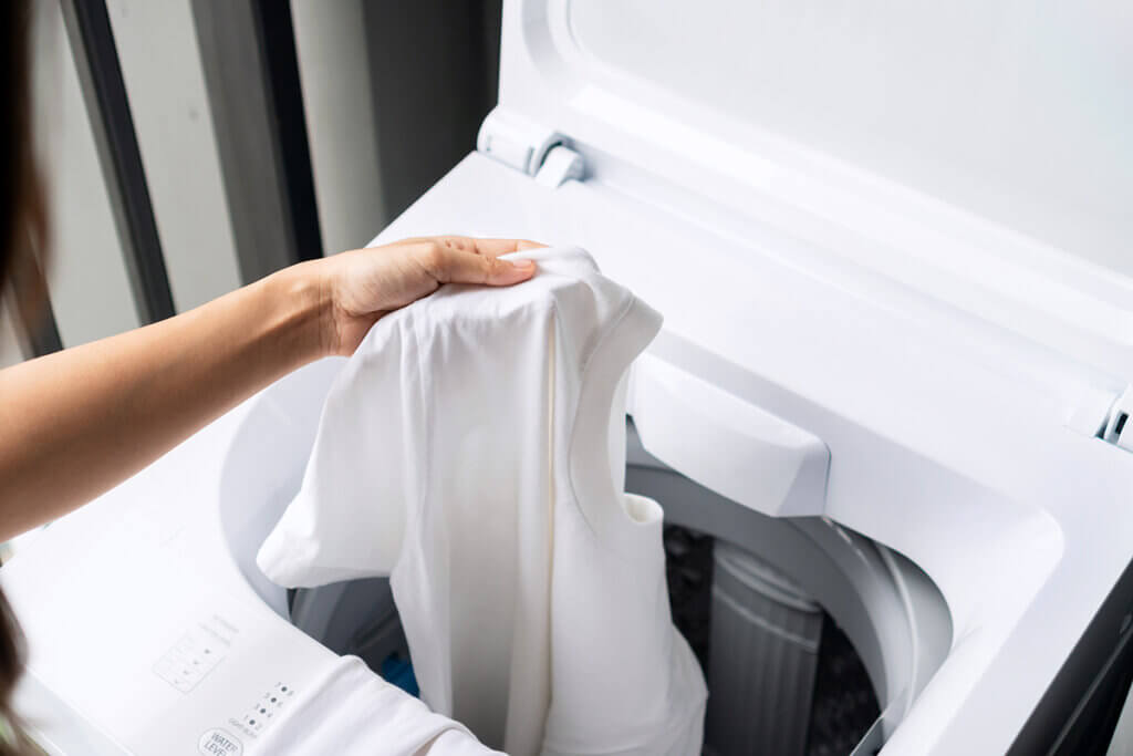 Wäsche wird aus Waschmaschine geholt
