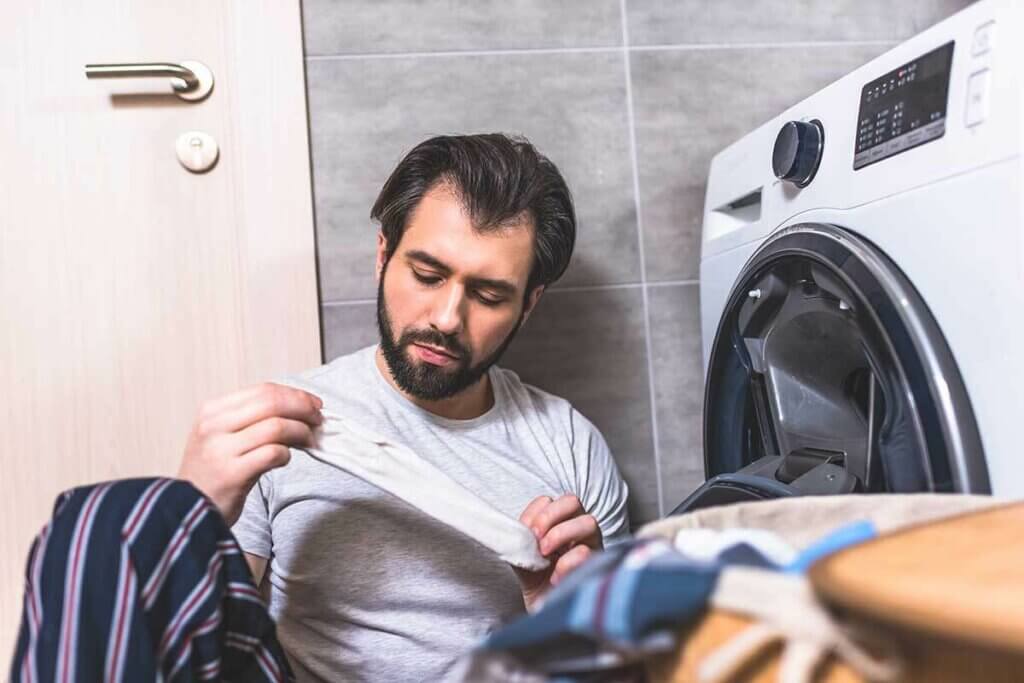 Mann beim Wäschesortieren