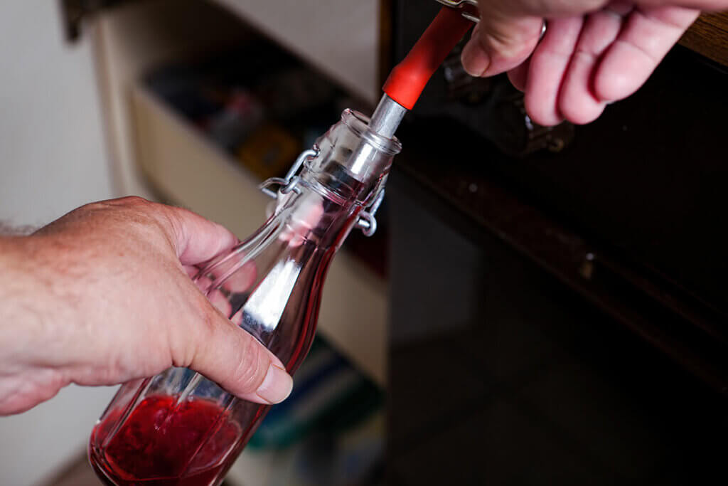 flasche wird mit johannisbeerensaft befuellt