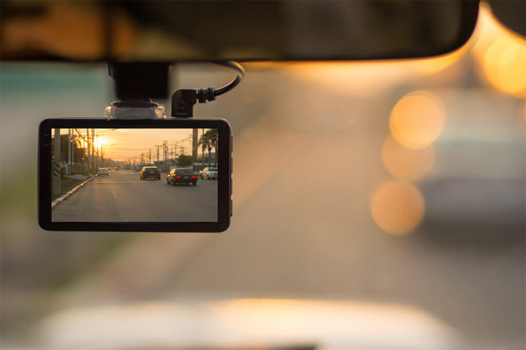 Aufnahme durch Frontscheibe mit Blick auf Dashcam und Strasse