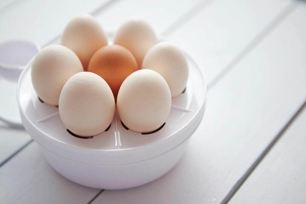 Ein runder Eierkocher mit sieben Eiern