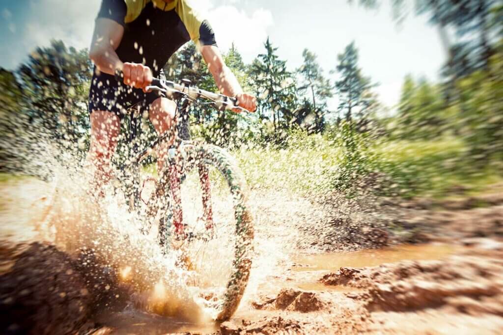 Radler faehrt durch Schlamm