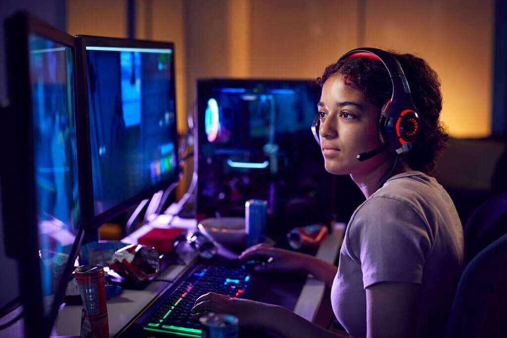 Frau sitzt am PC mit Headset