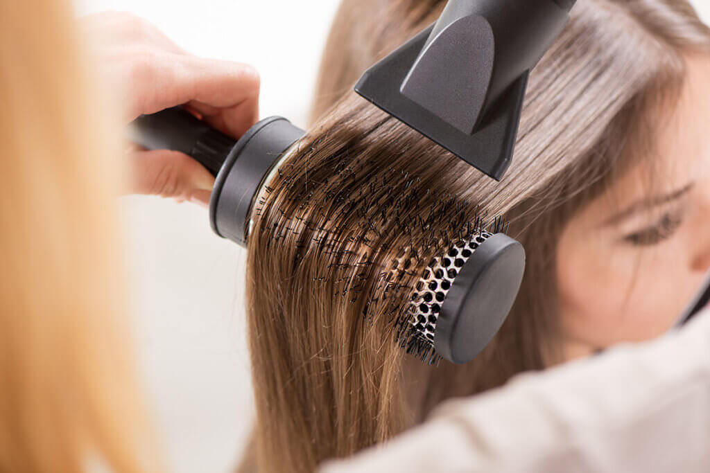 Frau trocknet sich die Haare