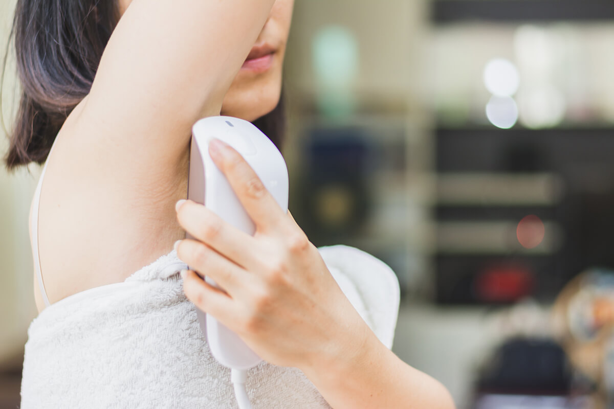 Frau entfernt Haare unter den Achseln