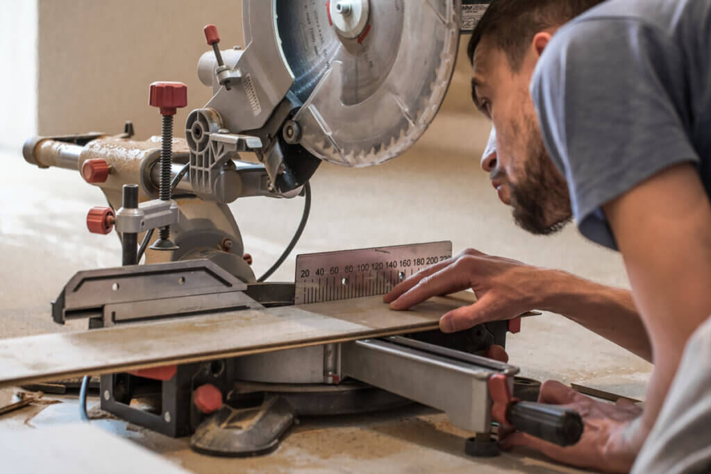 mann bei holzarbeit mit kappsaege