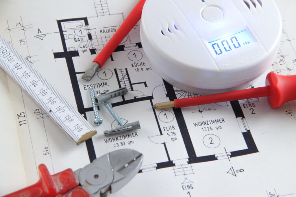 co melder auf bauplan mit zange und schraubenziehern