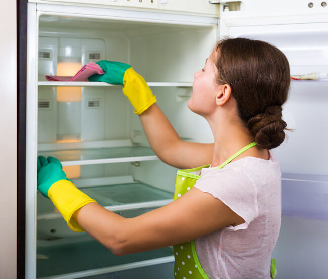 Person reinigt Kühlschrank
