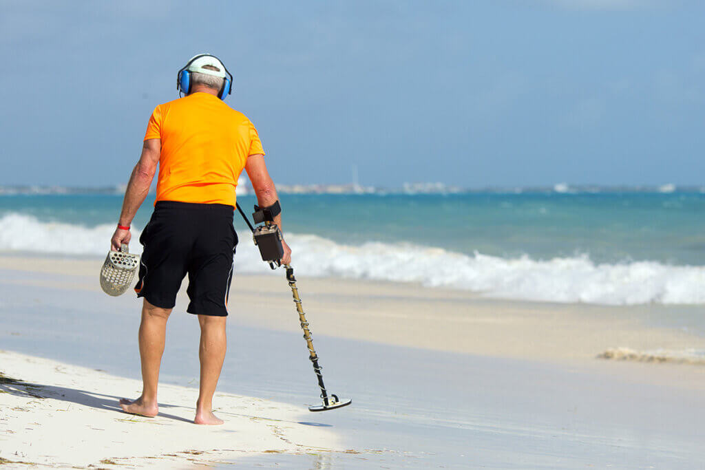 Mit Metalldetektor an Strand