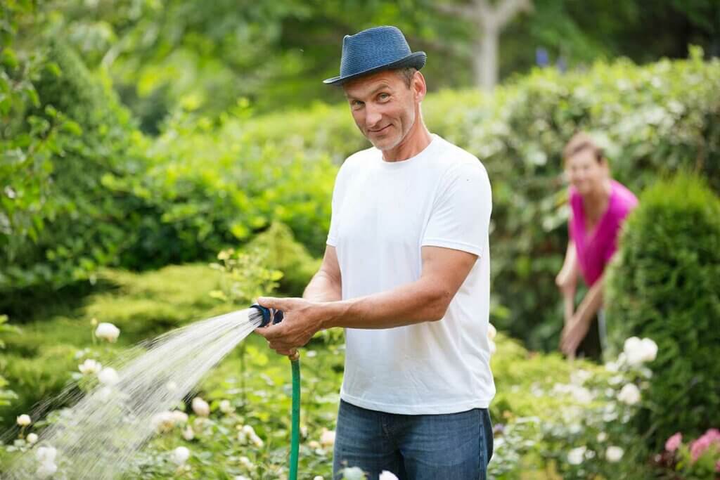 schlauchtrommel-mann bewaessert garten