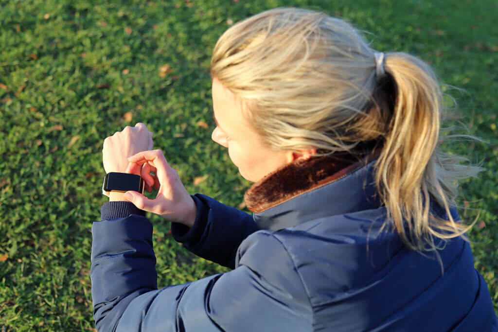 frau checkt ergebnisse des trainings auf schrittzähler
