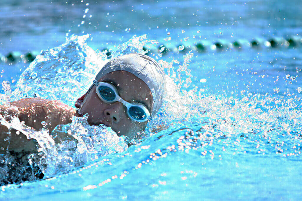 Person schwimmt Bahnen im Schwimmbad