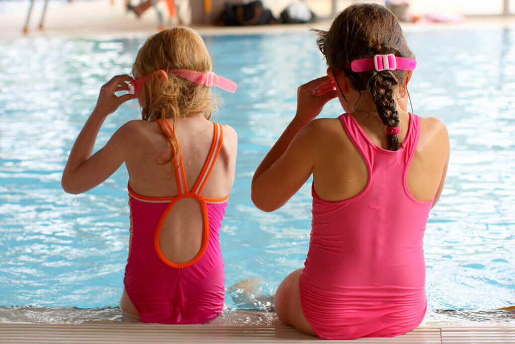 Zwei Mädchen sitzen am Poolrand