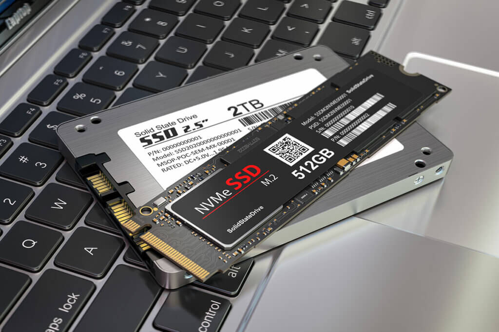 zwei SSDs liegen uebereinandergestapelt auf Laptop-Tastatur