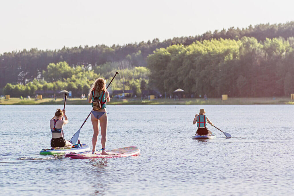 drei Personen auf SUP-Boards im Wasser