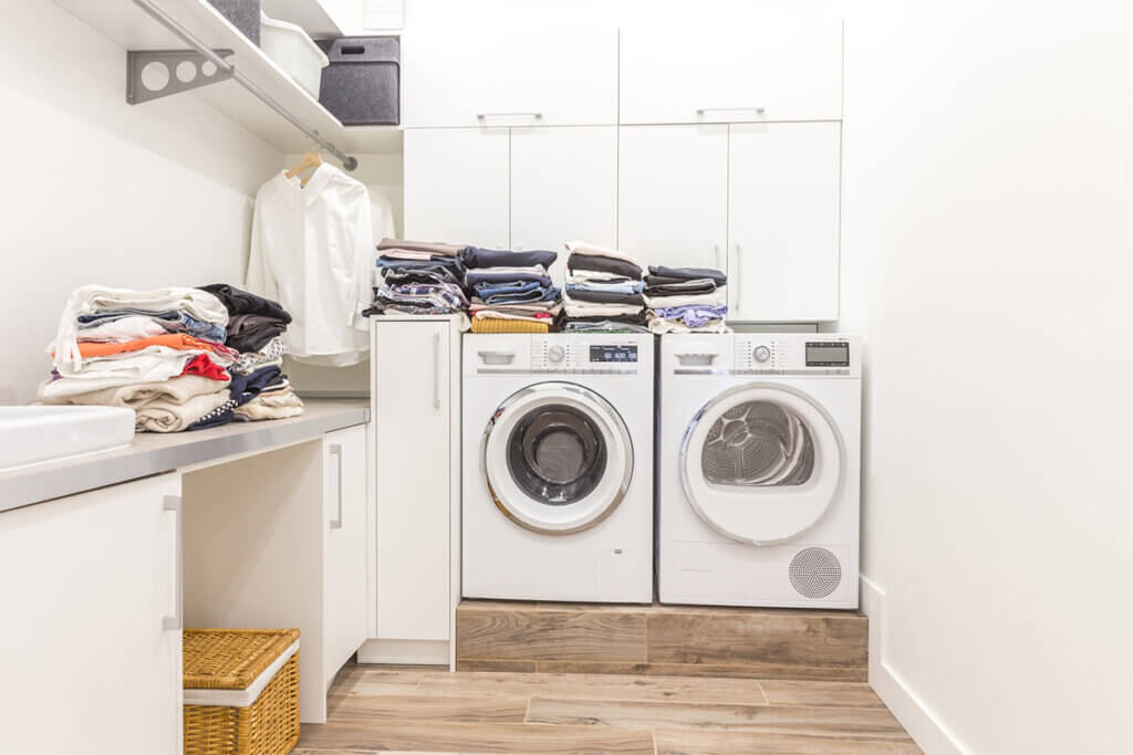 Waschmaschine und Trockner mit Wäsche in einem Raum
