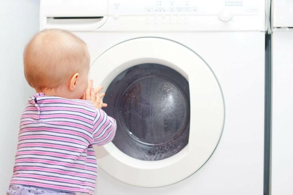Baby vor Waschmaschine