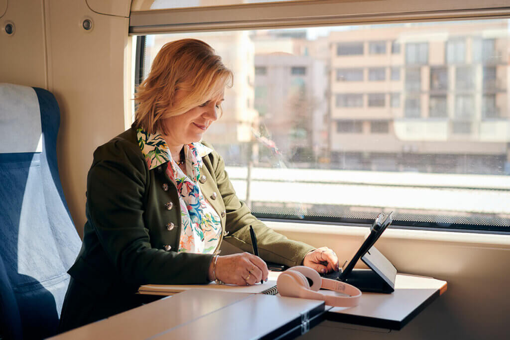 Frau arbeitet im Zug am Tablet