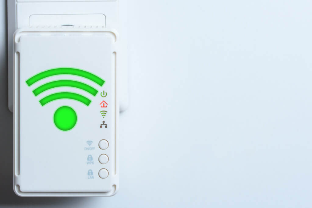 wlan repeater an einer wand mit gruenem wlan symbol